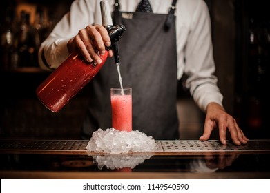 Bartender Pouring Alcoholic Sparkling Water Into A Glass With Sweet Red Berry Summer Cocktail On The Bar Counter