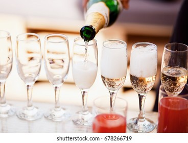 Bartender pouring champagne into glasses