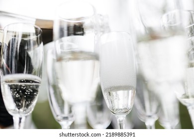 Bartender Pouring Champagne Or Wine Into Wine Glasses On The Table At The Outdoors Solemn Wedding Ceremony. 