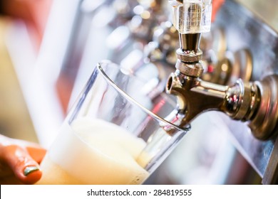 Bartender Pouring Draft Beer In The Bar.