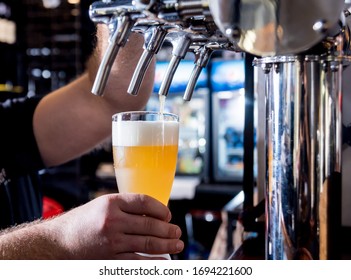 Bartender Pouring Draft Beer At Glasses In The Bar. Restaurant.