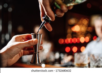 bartender is pouring drink into the steel  jigger. Close-up. Bartender pours whiskey into a measuring cup - Shutterstock ID 1732680632