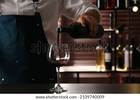 Bartender pouring red wine into glass at counter indoors, closeup Zdjęcia stock © 