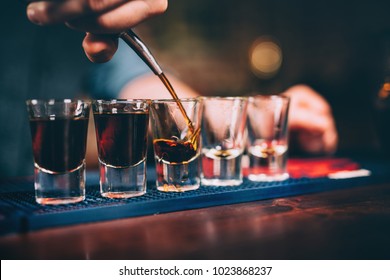 Bartender pouring and serving alcoholic drinks at bar 