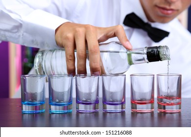 Bartender Is Pouring  Vodka Into Glasses