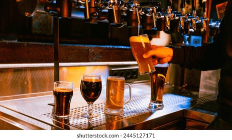 Bartender pouring wheat beer with three other varieties of beer on tap in foreground at traditional bar. Serving craft cold beer. Concept of alcohol drinks, nightlife, party, festivals, Oktoberfest. - Powered by Shutterstock