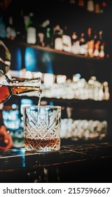 Bartender Pouring Whiskey From Bottle On Glass In Bar
