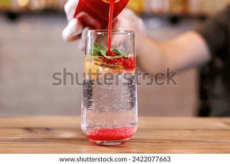 The bartender prepares a fresh summer cocktail of strawberries, lime and mint with ice cubes