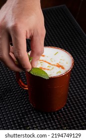 Bartender Preparing Moscow Mule With Mint On Top Of Drink Mug