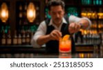 Bartender skillfully preparing a colorful cocktail at a dimly lit bar. The image is blurred, focusing on the vibrant atmosphere and the preparation process