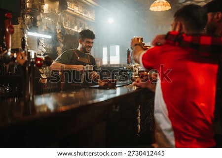 Bartender smiling while wiping the counter, serving men drinking beer at a bar enjoying social gathering and nightlife
