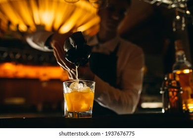 The Bartender Squeezes Citrus Juice Into A Cocktail