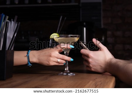 Bartender treats customer to margarita cocktail. Close-up.
