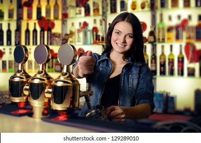 Bartender woman pours the beer into a glass - Powered by Shutterstock