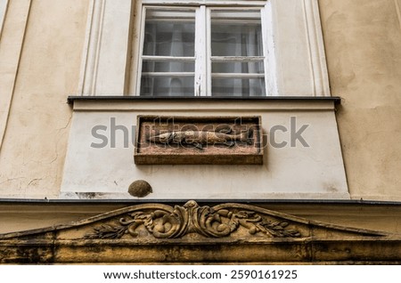 Bas relief of a pike on the facade of the House At the Golden Pike (in Czech 