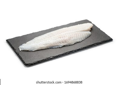 Basa Fish Fillet On A Black Stone Plate, Isolated On White Background.