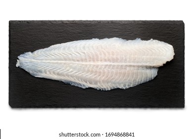 Basa Fish Fillet On A Black Stone Plate, Isolated On White Background, Top View.