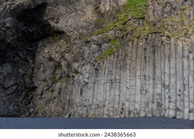 Basalt hexagonal columns rock formations in Halsanefshellir cave on Reynisfjara Black Sand Beach, Iceland.