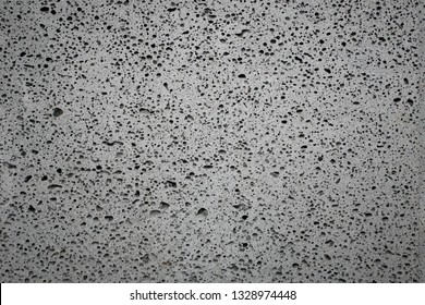 Basalt stone background .Basalt is a common extrusive igneous (volcanic) rock formed from the rapid cooling of basaltic lava exposed at or very near the surface of a planet or moon. - Shutterstock ID 1328974448