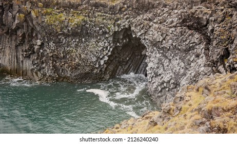 basaltic cave on a black beach in iceland, the waves beating against the rocks