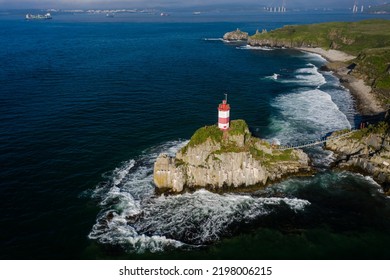 Basargin's lighthouse on a rocky island, to which the suspension bridge is stretched. The coastal beach. Vacation on the beach. Sea navigation. Drone view - Powered by Shutterstock