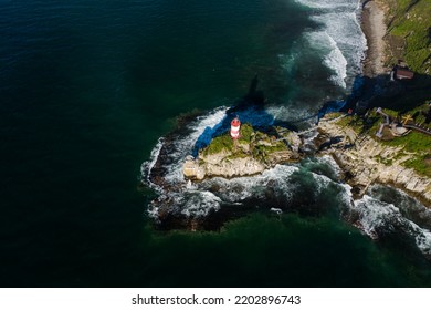 Basargin's lighthouse on a rocky island, to which the suspension bridge is stretched. The coastal beach. Vacation on the beach. Sea navigation. Drone view - Powered by Shutterstock