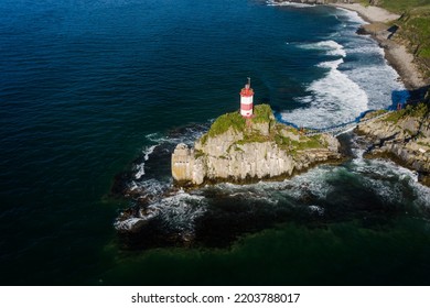 Basargin's lighthouse on a rocky island, to which the suspension bridge is stretched. The coastal beach. Vacation on the beach. Sea navigation. Drone view - Powered by Shutterstock