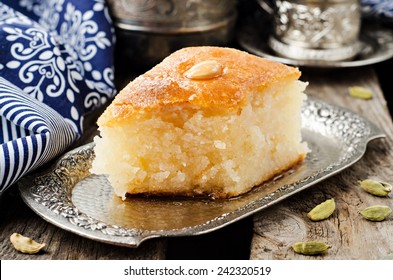 Basbousa (namoora) - Arabian Semolina Cake With Almond And Honey Syrup In Iron Tray On Wooden Background. Slice Of Cake