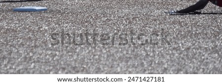 Base and baseball player on an artificial turf baseball field