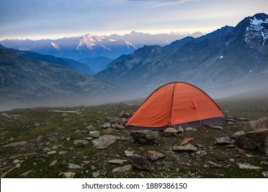 Base camp set in Alpine background. Ten set on hill i Alps mountains. Tourist shelter camp in high mountains.