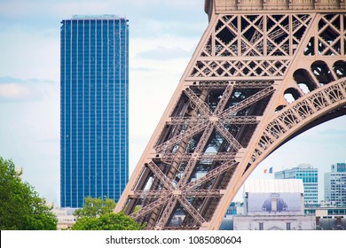 Base of the Eiffel tower with Montparnasse tower in background - Paris, France - Stock Image