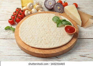 Base And Ingredients For Pizza On Wooden Table