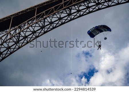 BASE jumper flying parachute under the New River Gorge Bridge in West Virginia during Bridge Day
