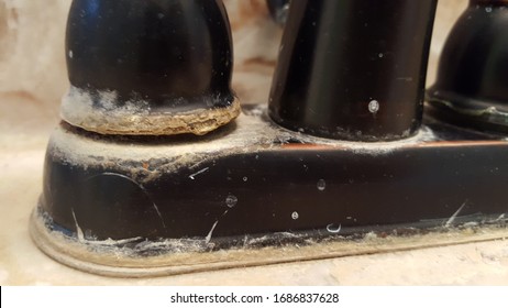 Base Of Wrought Iron Faucet With Hard Water Stains And Mineral Buildup