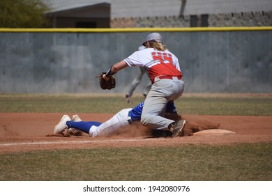 Baseball Action Shot Of A Baserunner Diving Back To First Base To Avoid A Tag