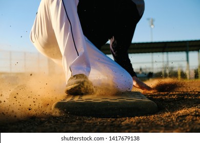 Baseball Athlete In Action, Sliding Into Base On Field Close Up Shows Movement Of Dirt.