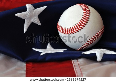 Baseball atop an American flag - American pastime.