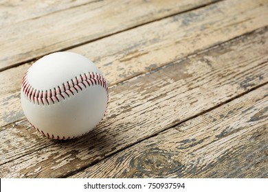 Baseball ball on old rustic wooden backstage.