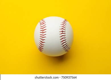 Baseball ball on yellow background with copy space.