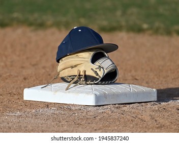 Baseball Base With A Glove And Hat Sitting On Top Of The Bag Waiting For The Player To Take The Field