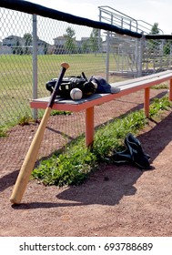 Baseball Bat, Ball, Gloves And Cleats On Baseball Team Bench