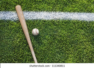 Baseball And Baseball Bat On Grass Field With White Stripe Viewed From Above