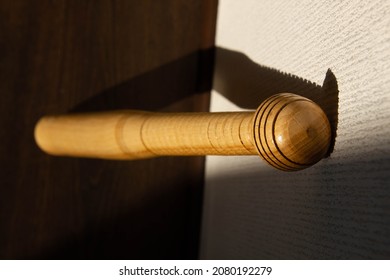 A Baseball Bat Stands Against The Wall. Beautiful Shadow Of The Sun From A Softball Bat Falls On The Wall. Sport Equipment. Carved Wooden Baseball Bat With Pattern. Copy Space For Text. Close-up