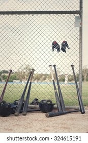 Baseball bats leaning against dugout fence. Processed with retro feel