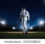 Baseball Batter walking up to home plate at a Baseball stadium ready to hit a home run during a baseball game at night under the stadium lights. Generic Baseball concept photo