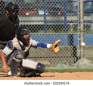 Baseball Catcher About To Catch A Pitched Ball. Slight Blur On Baseball As It Flies Into His Glove.