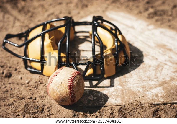 Baseball and catcher\'s\
mask on home plate