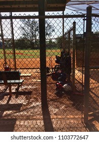 Baseball Dugout With Bats And Equipment Bags Back Lit Behind Fence