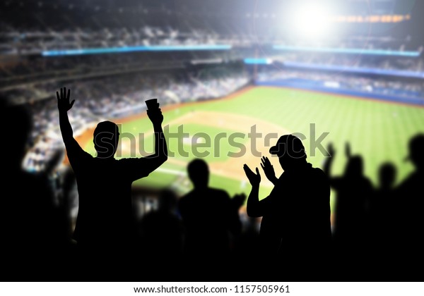 Baseball fans and crowd\
cheering in stadium and watching the game in ballpark. Happy people\
enjoying a match and sport event in arena. Friends watching\
ballgame live.