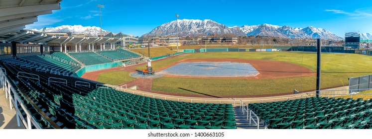 Baseball Field With Green Tiered Seating Against Mountain And Vibrant Blue Sky